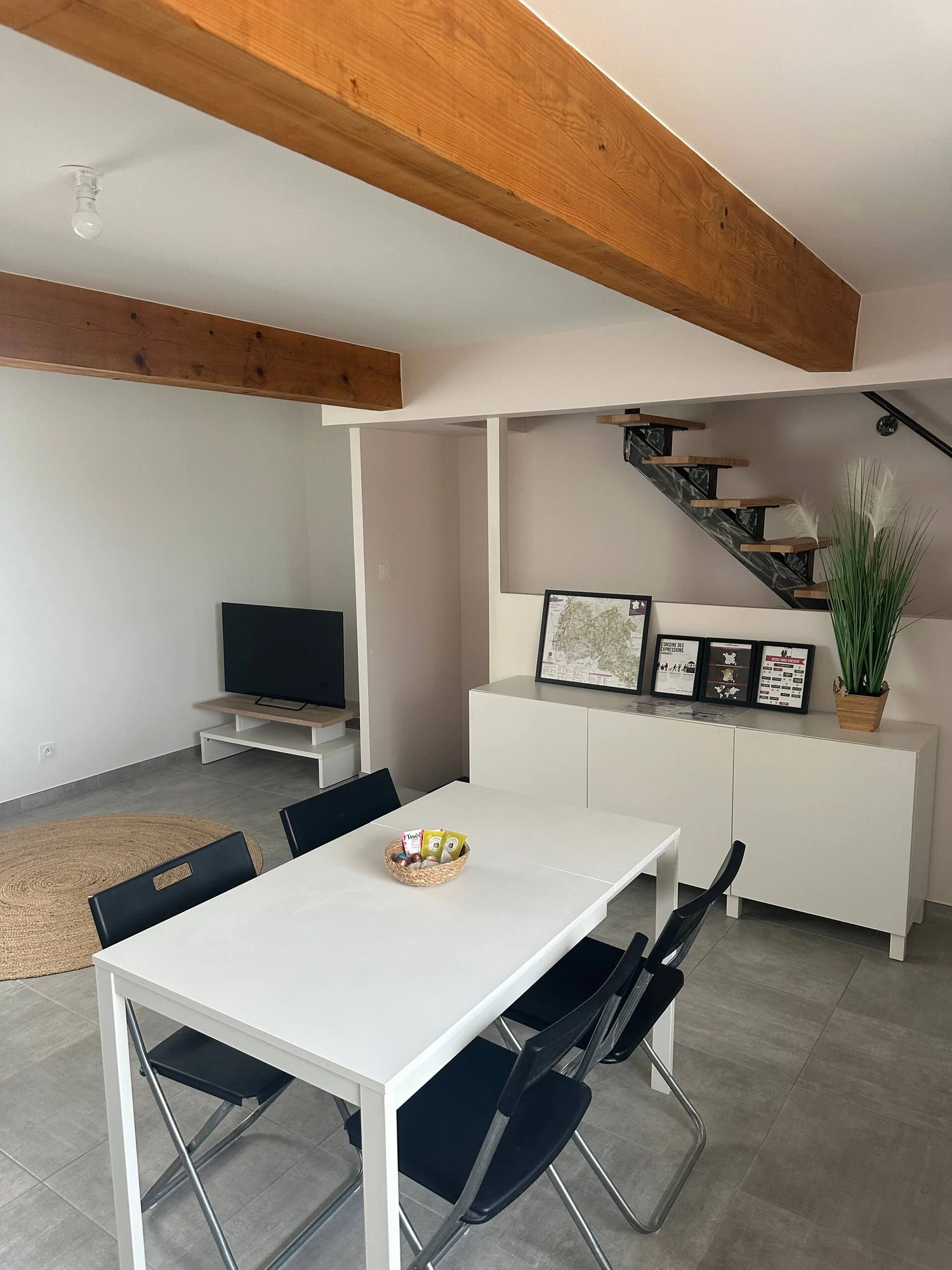 Duplex en campagne — la table, l’escalier et les poutres apparentes